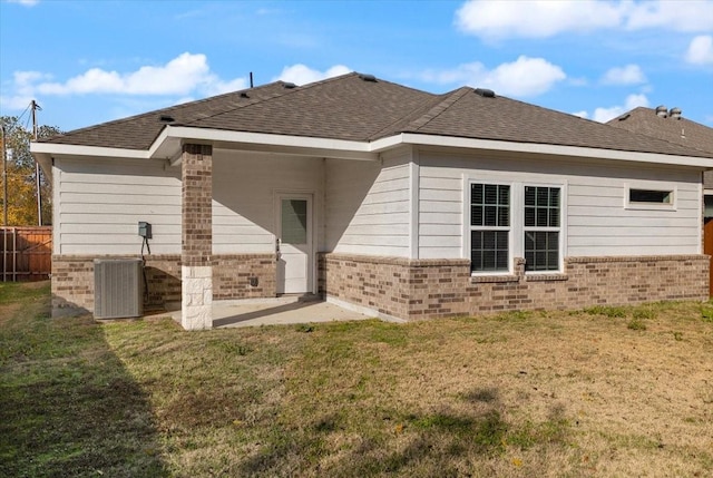 rear view of property with a lawn and central AC