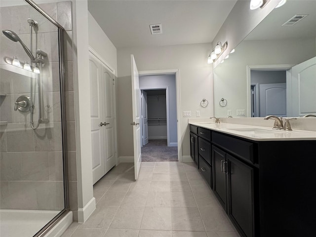 bathroom featuring tile patterned floors, a shower with door, and vanity