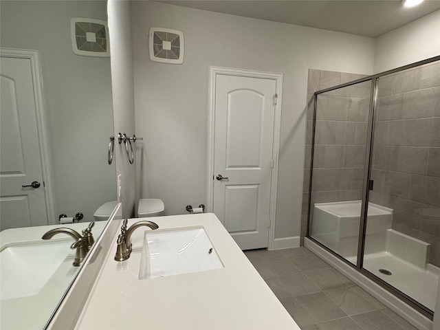 bathroom featuring tile patterned flooring, vanity, toilet, and a shower with shower door