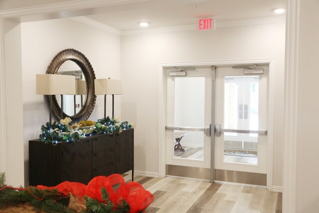 doorway to outside with ornamental molding and light hardwood / wood-style flooring