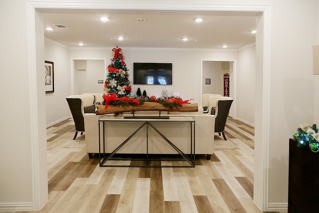 living room with light wood-type flooring and ornamental molding