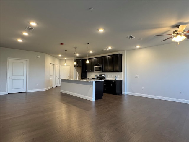 kitchen with pendant lighting, ceiling fan, an island with sink, dark hardwood / wood-style flooring, and stainless steel appliances