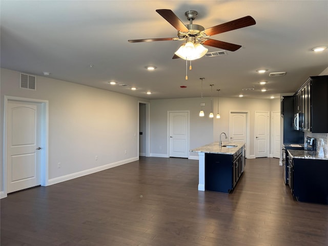 kitchen with a center island with sink, sink, dark hardwood / wood-style floors, black / electric stove, and light stone counters