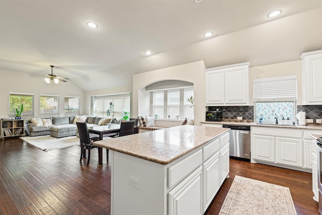 kitchen with a center island, stainless steel appliances, dark hardwood / wood-style flooring, lofted ceiling, and white cabinets