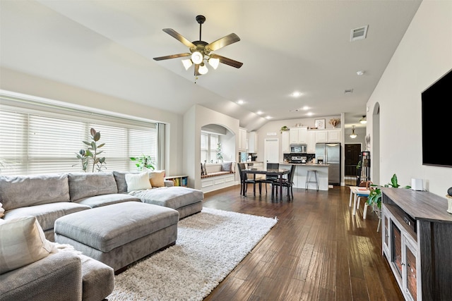 living room with ceiling fan, dark hardwood / wood-style floors, and vaulted ceiling