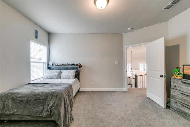 bedroom featuring carpet floors, baseboards, multiple windows, and visible vents