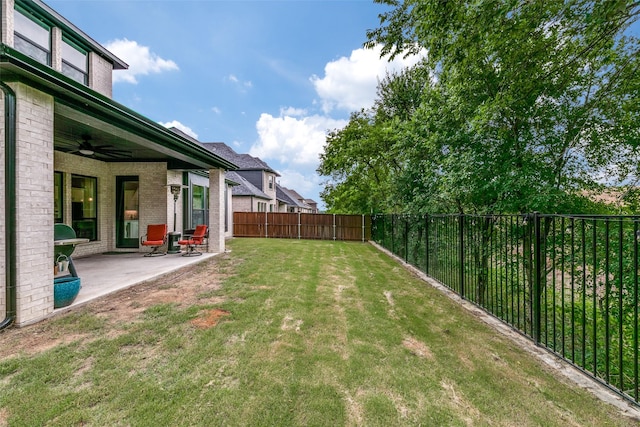 view of yard with ceiling fan, a patio area, and a fenced backyard