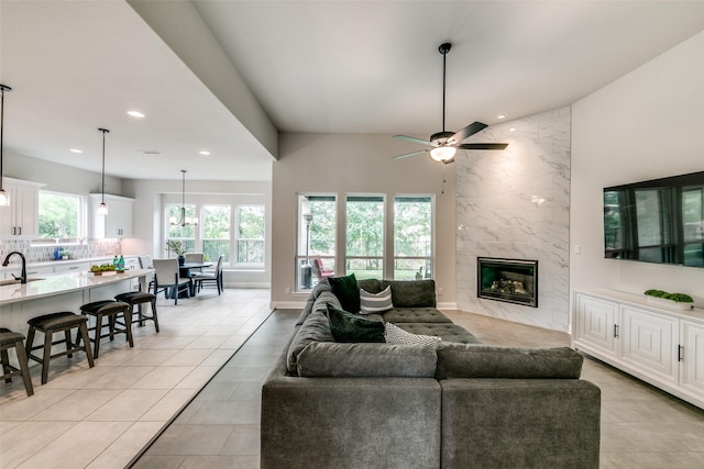 living room featuring light tile patterned floors, a fireplace, a ceiling fan, and recessed lighting