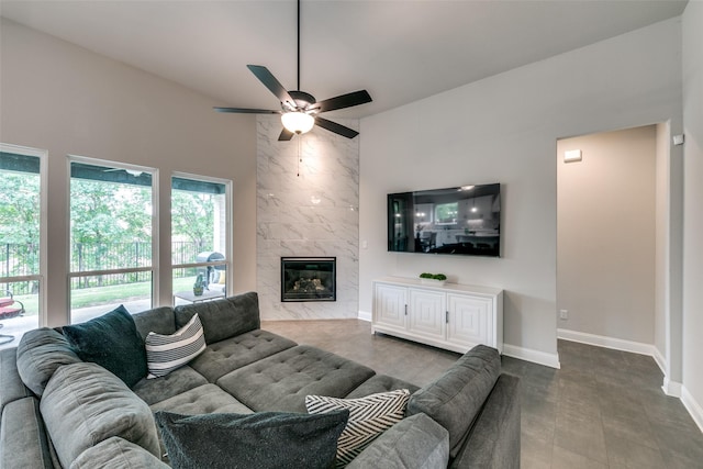 living area with ceiling fan, a fireplace, and baseboards