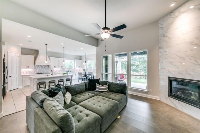 living area featuring recessed lighting, visible vents, a high end fireplace, ceiling fan, and baseboards