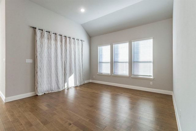 empty room with wood-type flooring and lofted ceiling