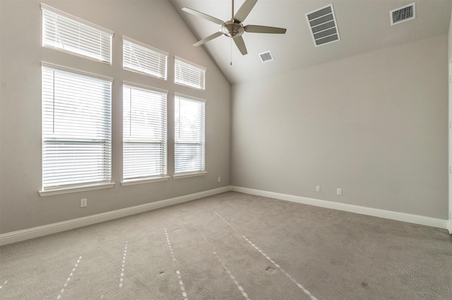 carpeted spare room with ceiling fan and high vaulted ceiling