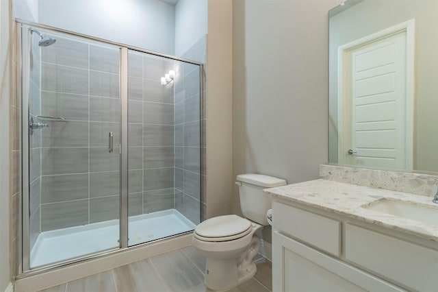 bathroom with vanity, toilet, and a shower with door