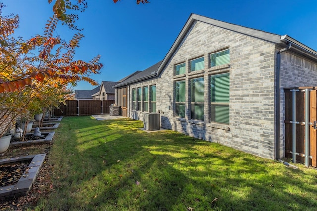 rear view of house with central AC, a yard, and a patio