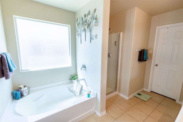 bathroom featuring plus walk in shower, tile patterned flooring, and a healthy amount of sunlight