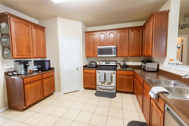 kitchen featuring light tile patterned flooring, appliances with stainless steel finishes, and sink