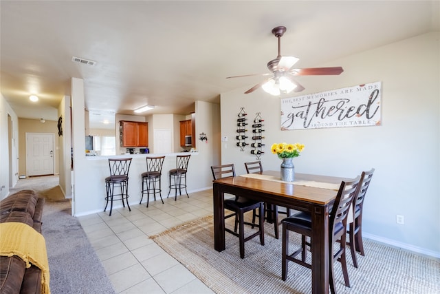 tiled dining area featuring ceiling fan