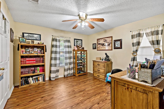 office area with wood-type flooring, a textured ceiling, and ceiling fan