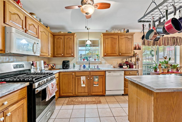 kitchen with ornamental molding, white appliances, sink, pendant lighting, and light tile patterned flooring