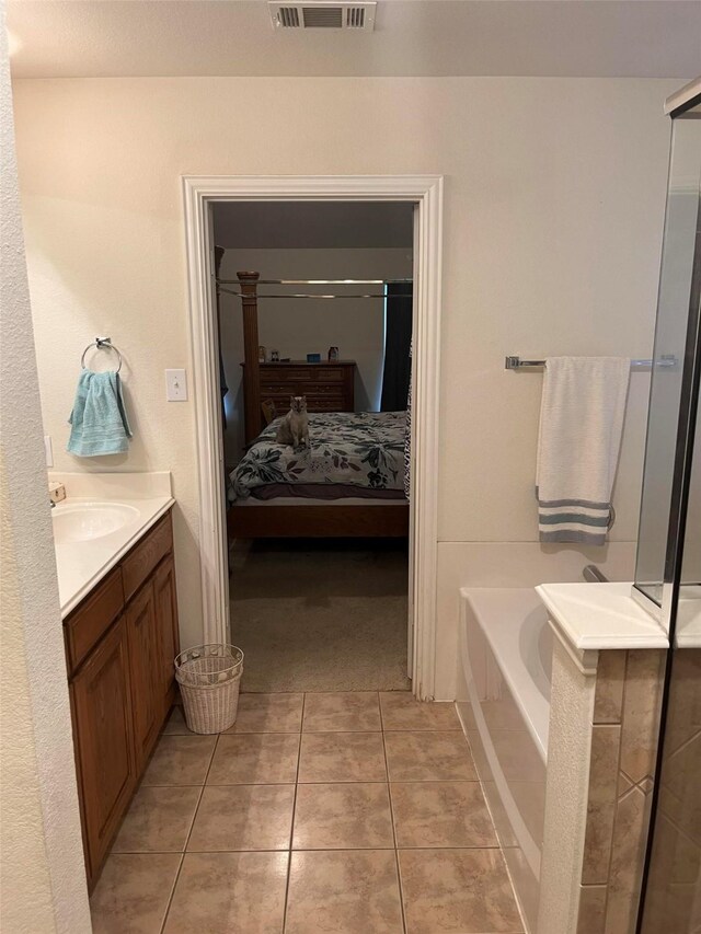 bathroom with vanity, a tub to relax in, and tile patterned floors