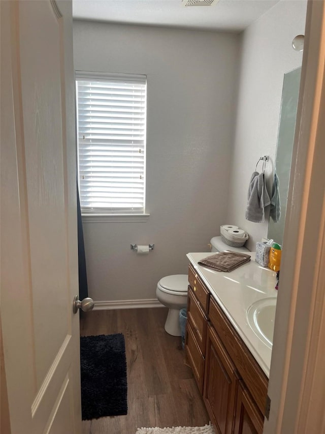 bathroom featuring vanity, hardwood / wood-style flooring, and toilet