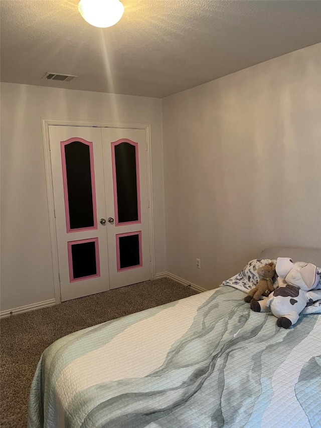 carpeted bedroom with french doors, a closet, and a textured ceiling