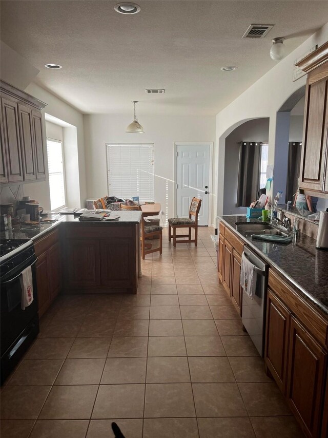 kitchen featuring dishwasher, dark tile patterned flooring, sink, electric range, and kitchen peninsula