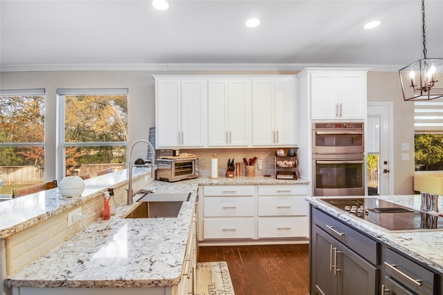 kitchen featuring white cabinets, sink, and hanging light fixtures