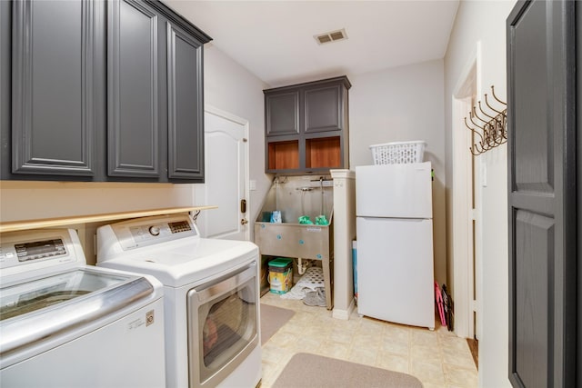 washroom with washer and dryer and cabinets