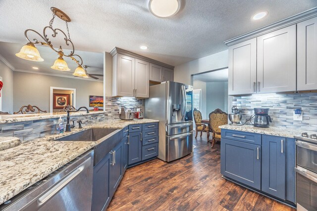 kitchen with sink, hanging light fixtures, stainless steel appliances, dark hardwood / wood-style floors, and backsplash