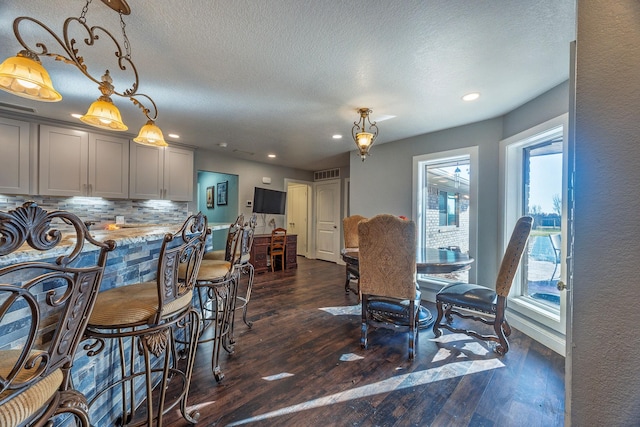 dining room featuring a textured ceiling and dark wood-type flooring