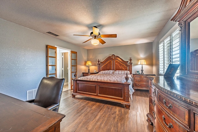 bedroom featuring french doors, a textured ceiling, dark hardwood / wood-style floors, and ceiling fan