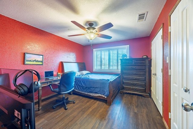 bedroom featuring a textured ceiling, ceiling fan, and dark hardwood / wood-style floors