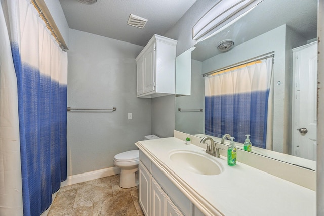 bathroom featuring vanity, a textured ceiling, and toilet