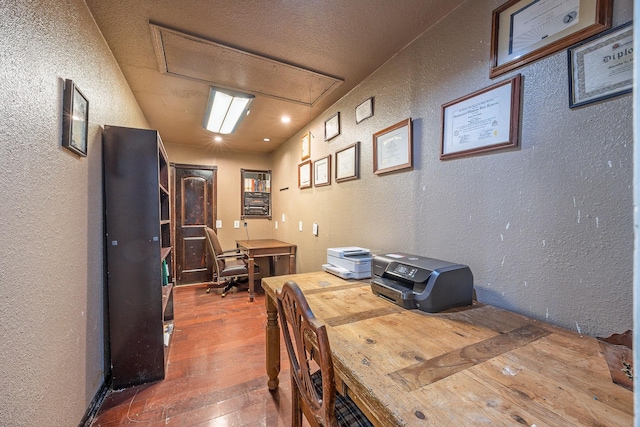 dining space with hardwood / wood-style flooring and a textured ceiling