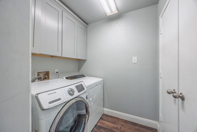 laundry area with cabinets, a textured ceiling, dark hardwood / wood-style floors, and washer and dryer