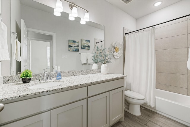 full bathroom with hardwood / wood-style floors, vanity, toilet, and shower / bath combo with shower curtain