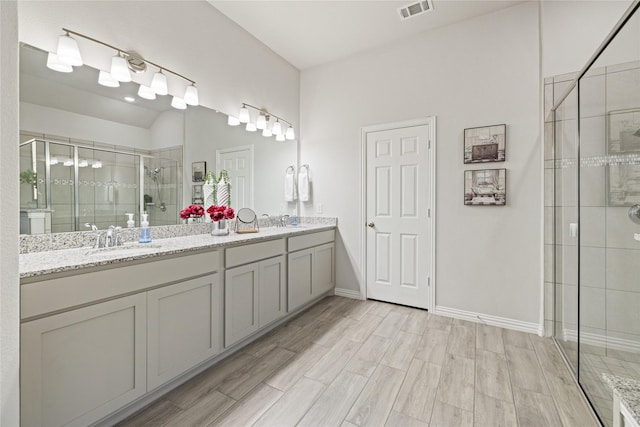 bathroom with vanity, wood-type flooring, and an enclosed shower