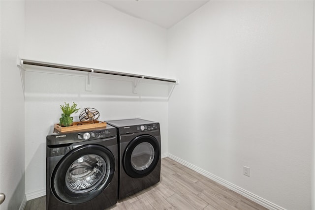 laundry area featuring light wood-type flooring and washing machine and clothes dryer