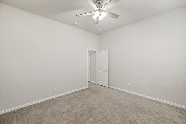 empty room with light colored carpet, ceiling fan, and lofted ceiling