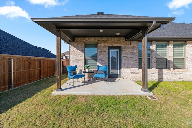 rear view of house featuring a yard and a patio