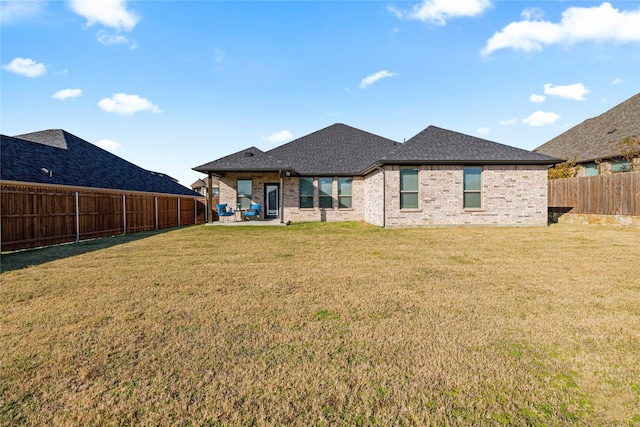 back of house featuring a lawn and a patio