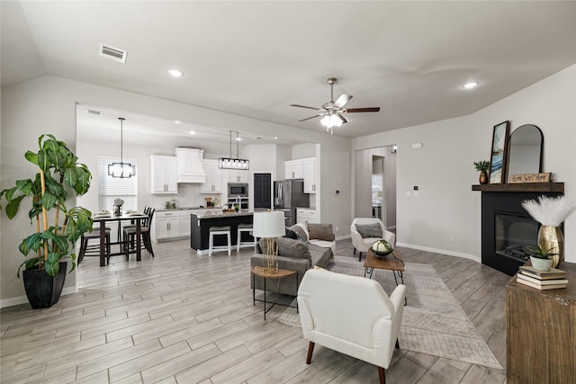 living room featuring light wood-type flooring, ceiling fan, and lofted ceiling