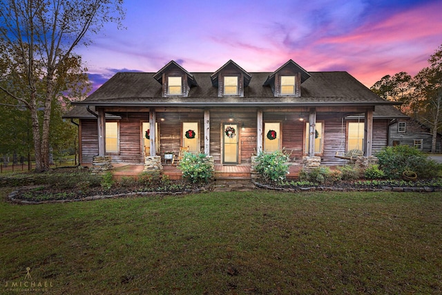 new england style home with a lawn and covered porch