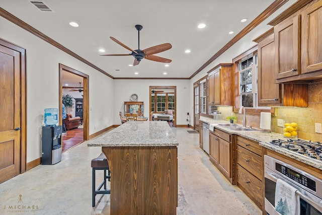 kitchen featuring light stone counters, decorative backsplash, appliances with stainless steel finishes, and a kitchen island