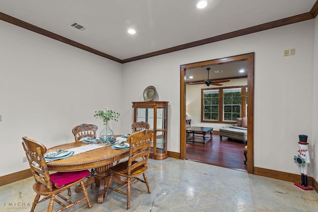 dining area with concrete flooring, crown molding, and ceiling fan