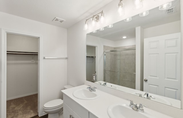 bathroom with vanity, toilet, and a shower with door