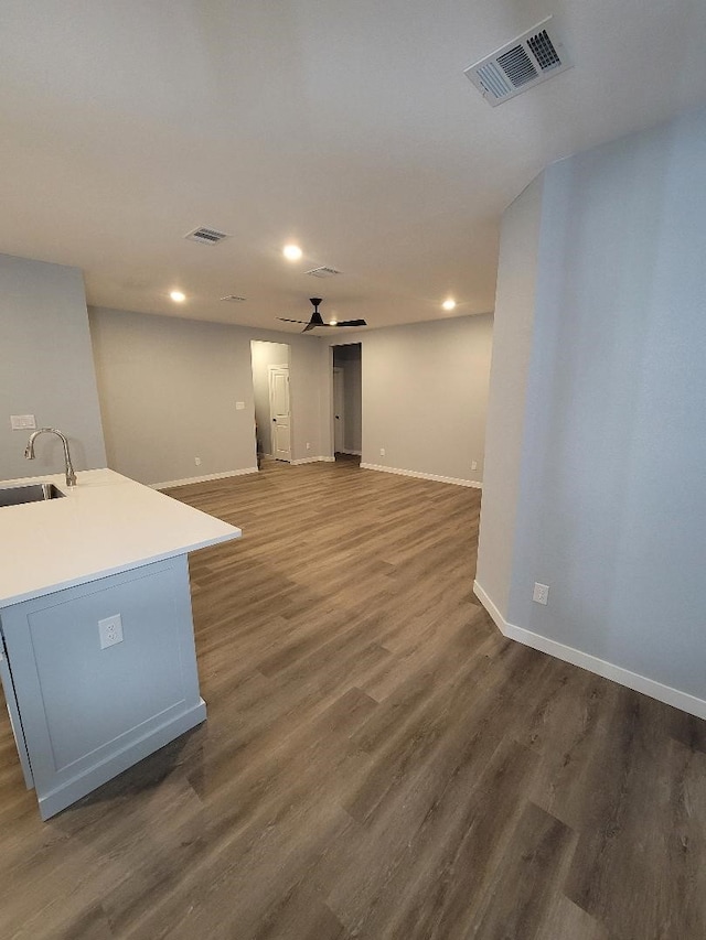 interior space featuring baseboards, visible vents, dark wood finished floors, and a sink