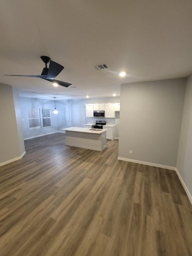 unfurnished living room featuring ceiling fan, dark wood-style flooring, visible vents, and baseboards