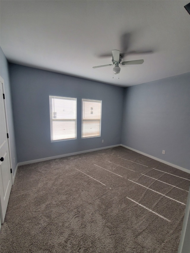 carpeted spare room featuring ceiling fan